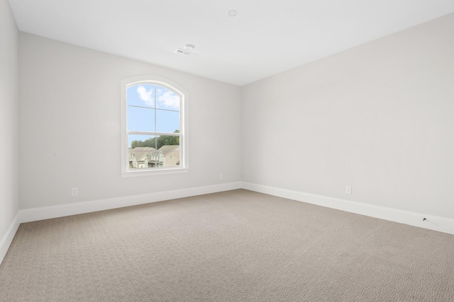 carpeted empty room featuring visible vents and baseboards