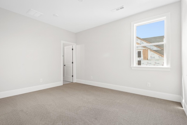 unfurnished room with baseboards, visible vents, and carpet flooring