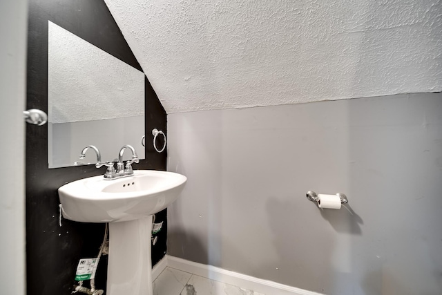 106 Windellwood Cir, Smyrna, TN 37167 - bathroom with a textured ceiling, vaulted ceiling, marble look tiles, and baseboards
