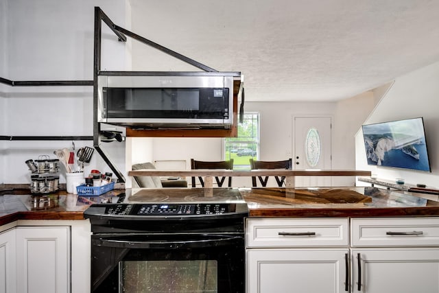 106 Windellwood Cir, Smyrna, TN 37167 - kitchen with electric range, stainless steel microwave, white cabinets, a textured ceiling, and wooden counters