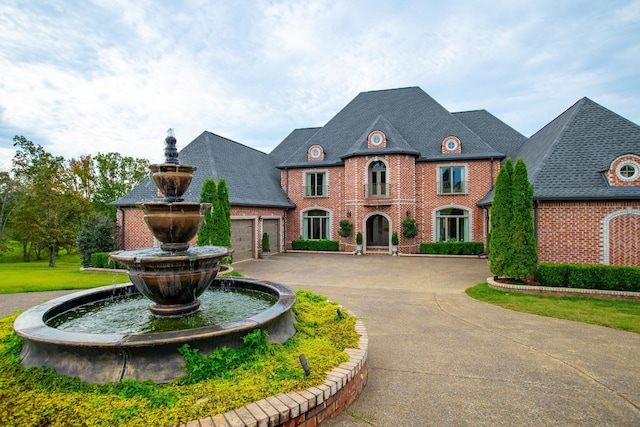 140 Lake Shore Ln, Henderson, TN 38340 - french country style house featuring a garage, brick siding, and curved driveway