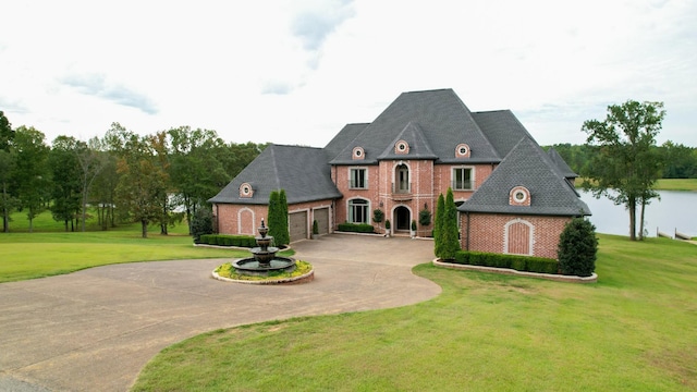140 Lake Shore Ln, Henderson, TN 38340 - french country style house featuring an attached garage, a front yard, brick siding, and curved driveway