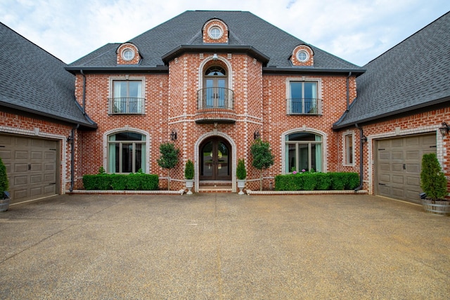 140 Lake Shore Ln, Henderson, TN 38340 - french country style house with concrete driveway, a balcony, french doors, and brick siding