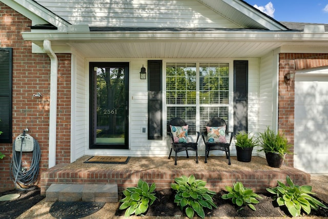 2561 Edinburgh St, Old Hickory, TN 37138 - view of exterior entry featuring a porch, brick siding, and a garage