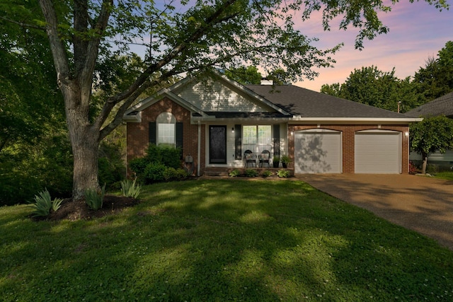 2561 Edinburgh St, Old Hickory, TN 37138 - view of front facade with covered porch, driveway, a lawn, a garage, and brick siding