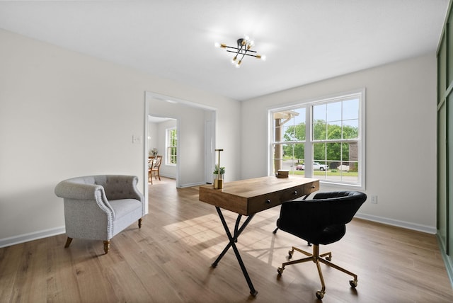 home office featuring baseboards, wood finished floors, and a notable chandelier