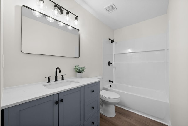 full bath featuring visible vents, tub / shower combination, toilet, wood finished floors, and vanity