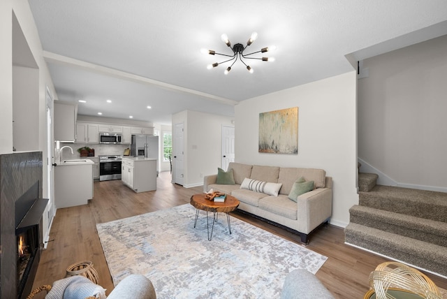 living area featuring a chandelier, recessed lighting, light wood-style flooring, and stairs