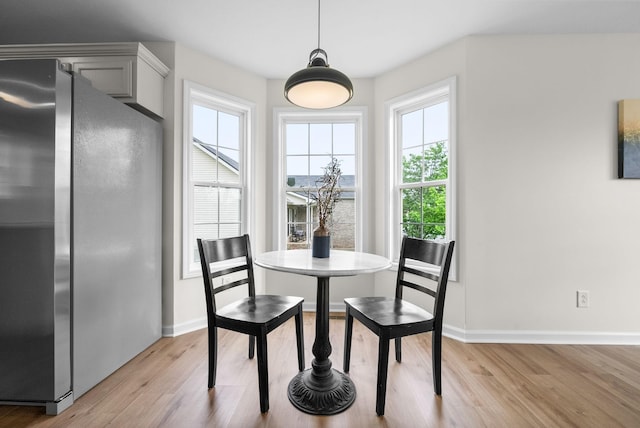 dining space featuring baseboards and light wood-type flooring