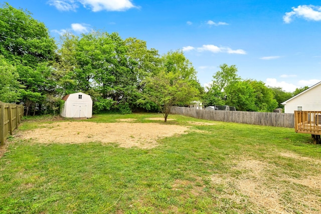 view of yard featuring fence, a storage unit, and an outdoor structure