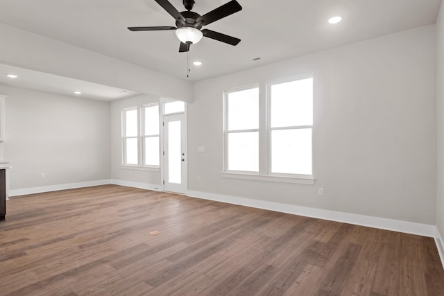 unfurnished living room with visible vents, ceiling fan, wood finished floors, and baseboards