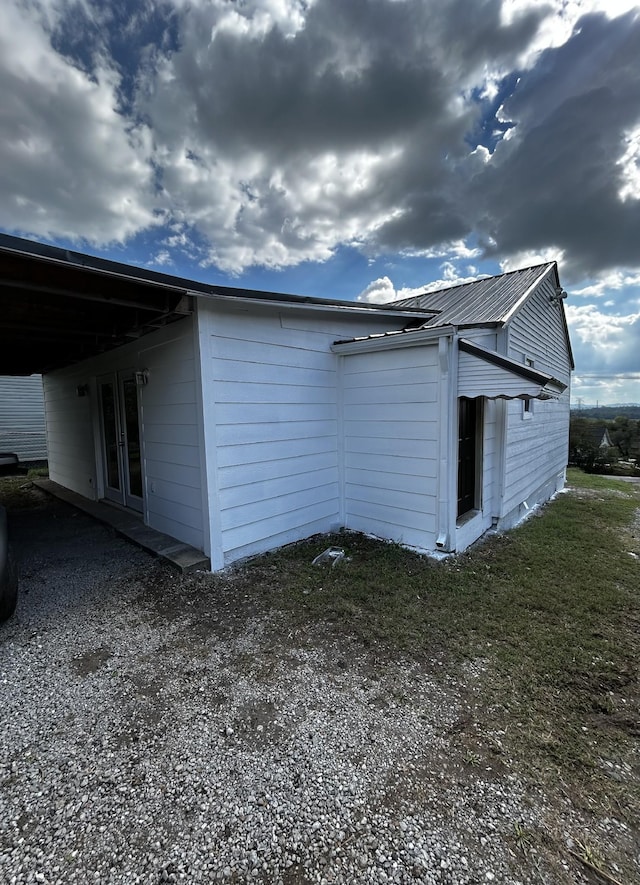 view of side of property featuring metal roof and french doors