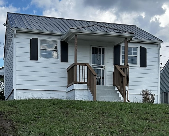 single story home featuring a standing seam roof, a front lawn, and metal roof