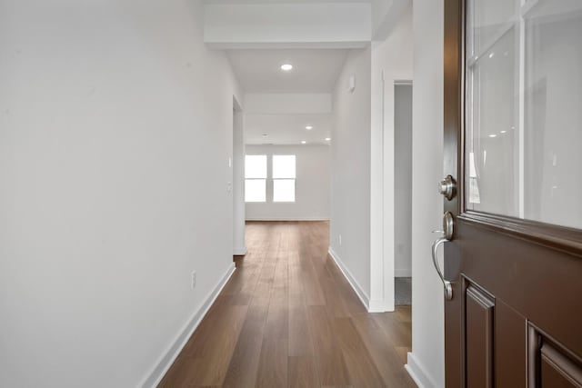 hallway with baseboards, recessed lighting, and wood finished floors