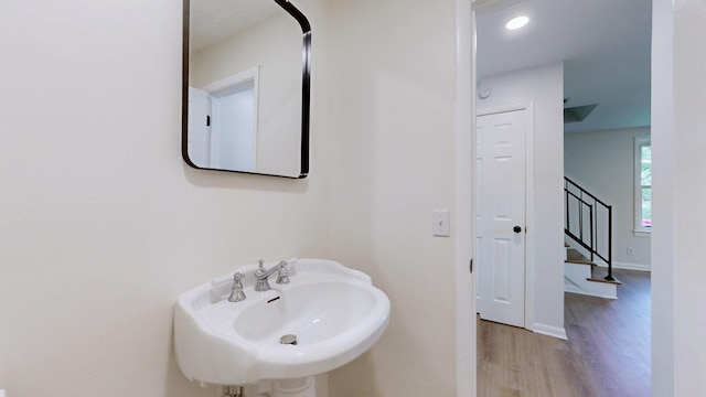 bathroom with a sink, wood finished floors, and baseboards