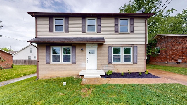 view of front facade with fence, a front yard, and brick siding