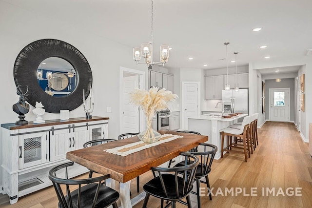dining room with visible vents, baseboards, recessed lighting, light wood finished floors, and a notable chandelier