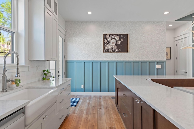 kitchen featuring light countertops, plenty of natural light, a sink, and dishwasher