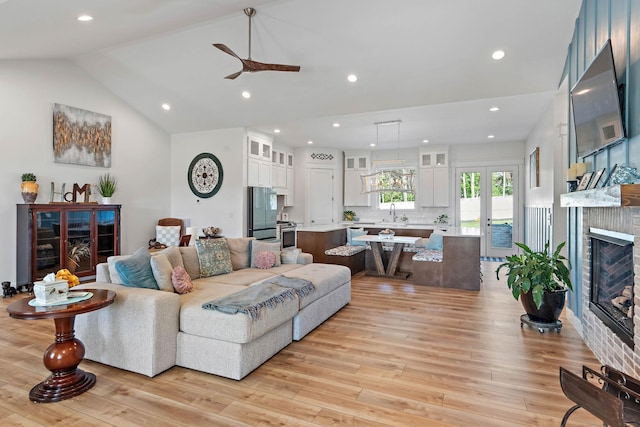 living room featuring recessed lighting, ceiling fan, a glass covered fireplace, and light wood finished floors