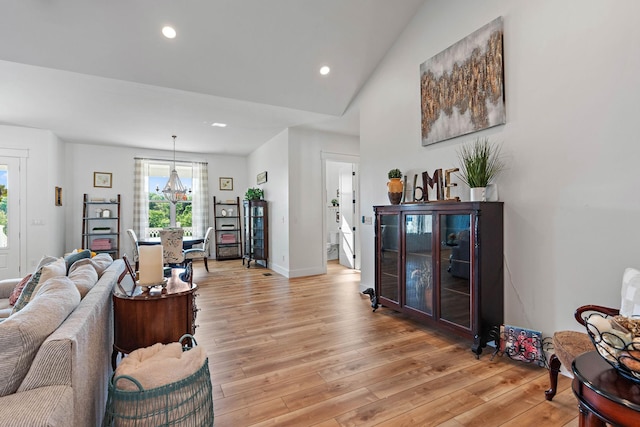 living room with light wood-style floors, baseboards, an inviting chandelier, and recessed lighting