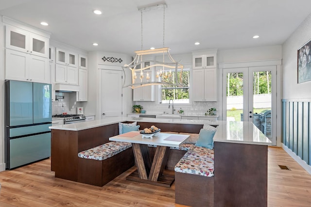 kitchen with a center island, light countertops, appliances with stainless steel finishes, and tasteful backsplash