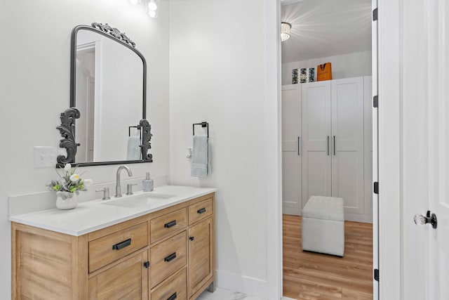 bathroom with baseboards, wood finished floors, and vanity