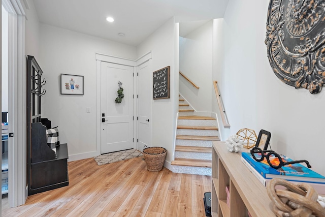 foyer entrance featuring stairs, recessed lighting, baseboards, and light wood-style floors