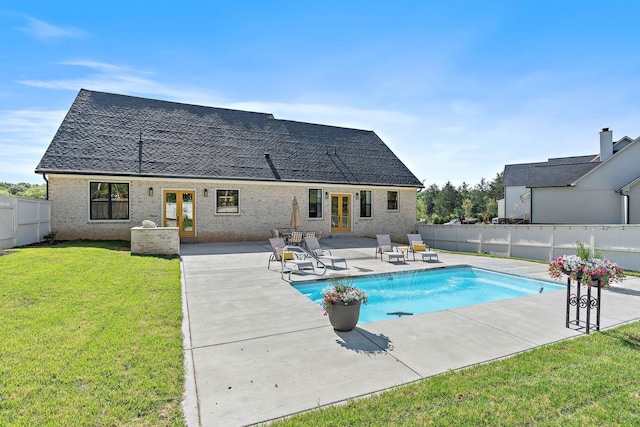 view of pool with a patio, a fenced backyard, french doors, a fenced in pool, and a lawn