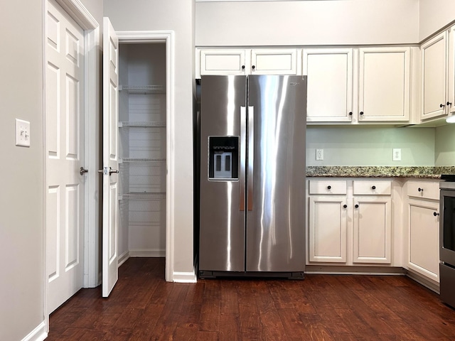 kitchen with dark wood-style floors, white cabinets, stainless steel refrigerator with ice dispenser, and dark stone counters