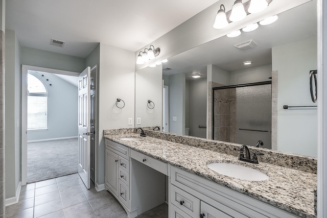 bathroom with a sink, a shower stall, and visible vents