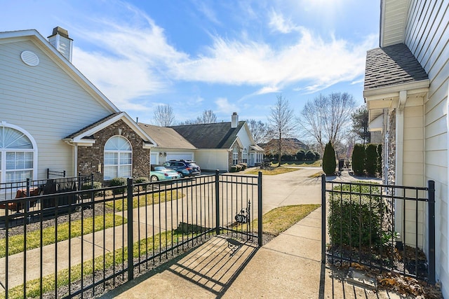 view of patio / terrace featuring a residential view, concrete driveway, and fence