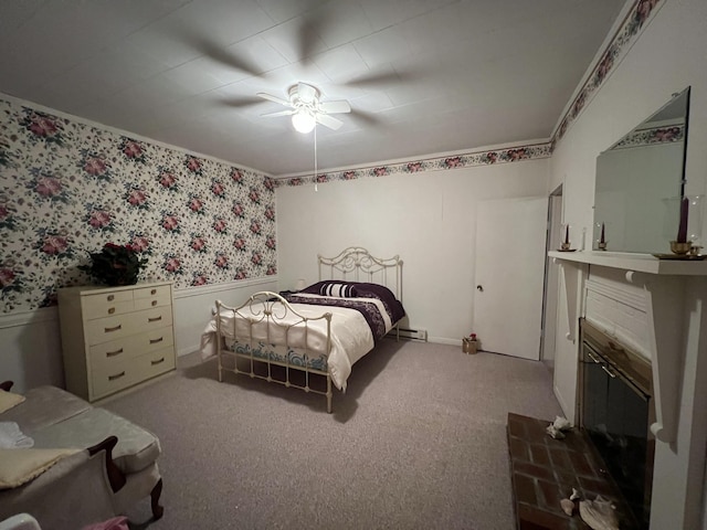 carpeted bedroom featuring wallpapered walls, a wainscoted wall, and ceiling fan
