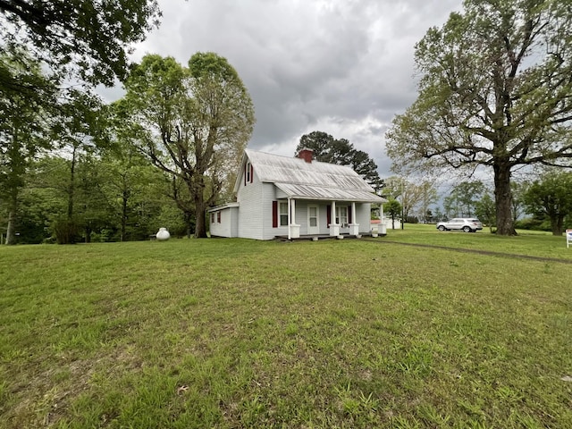 exterior space featuring a front lawn, covered porch, and a chimney