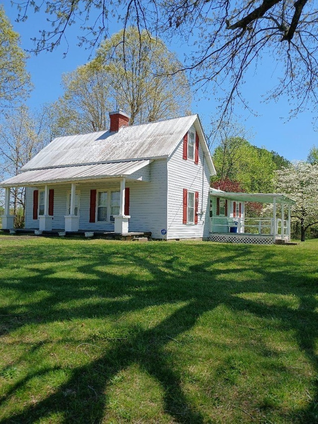exterior space featuring covered porch, a chimney, a front yard, and crawl space