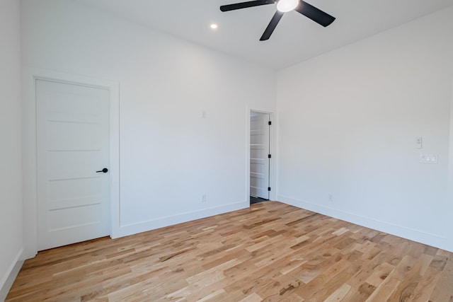 spare room featuring baseboards, light wood-type flooring, a ceiling fan, and recessed lighting