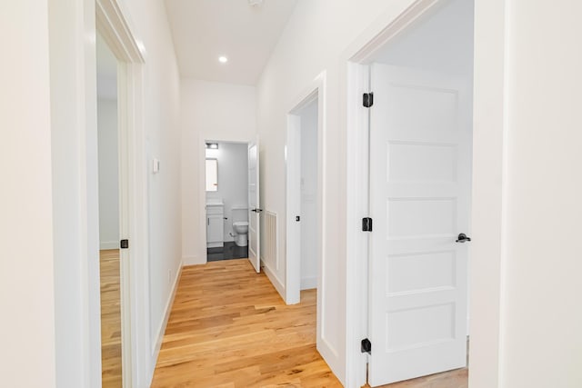 hallway featuring recessed lighting, baseboards, and light wood-style floors