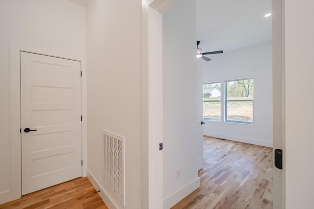 hallway featuring baseboards, visible vents, light wood-type flooring, and recessed lighting