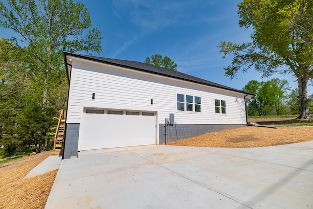 view of side of property featuring driveway and a garage