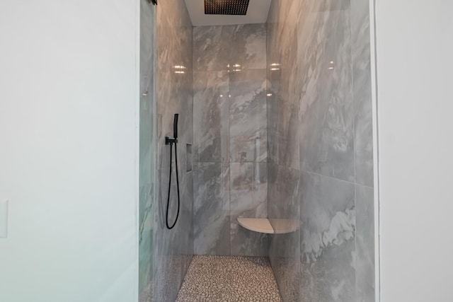 bathroom with a marble finish shower