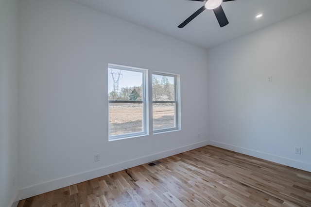 unfurnished room with wood finished floors, visible vents, and baseboards