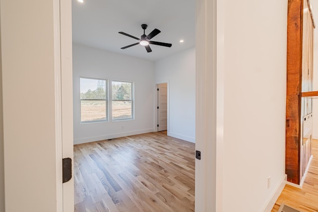 empty room featuring wood finished floors, recessed lighting, and baseboards