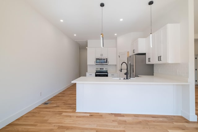 kitchen with white cabinetry, decorative backsplash, a sink, stainless steel appliances, and light countertops