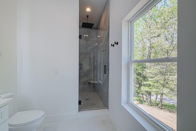 bathroom featuring a stall shower, marble finish floor, a healthy amount of sunlight, and baseboards