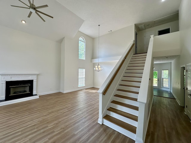 unfurnished living room with wood finished floors, a wealth of natural light, and high vaulted ceiling