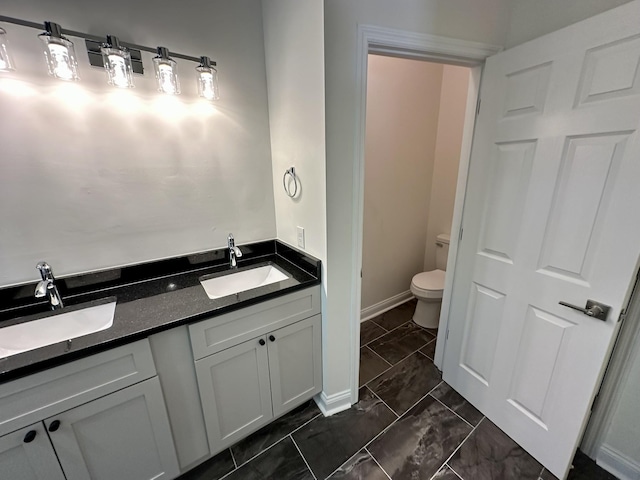 full bathroom featuring a sink, baseboards, toilet, and marble finish floor