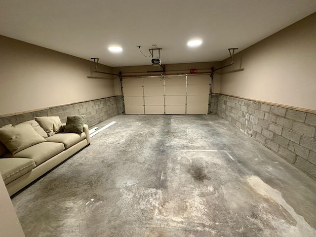 garage with a wainscoted wall and a garage door opener