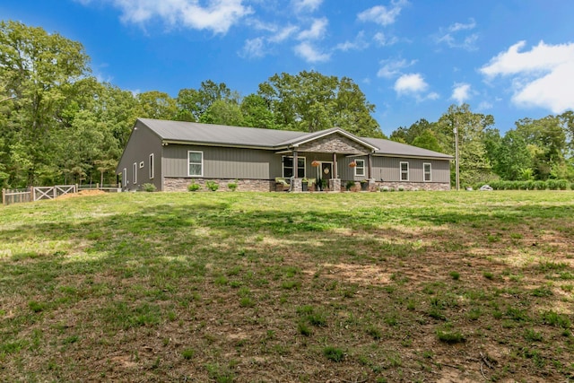 ranch-style home with fence, a front lawn, and stone siding