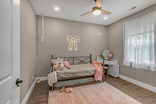 bedroom with wood finished floors, visible vents, and baseboards