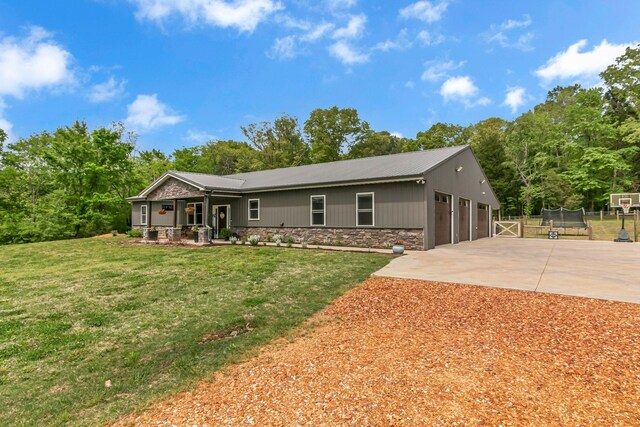 single story home featuring a front lawn, covered porch, driveway, stone siding, and fence