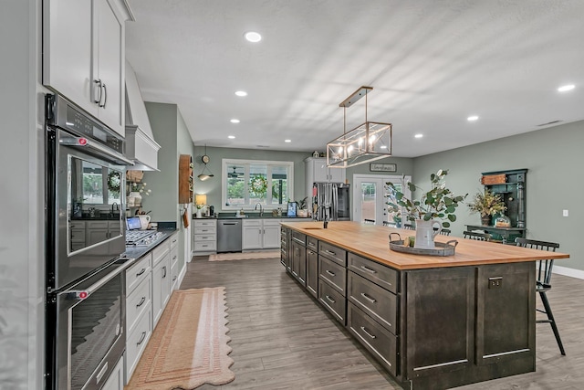 kitchen with recessed lighting, wood counters, wood finished floors, and stainless steel appliances
